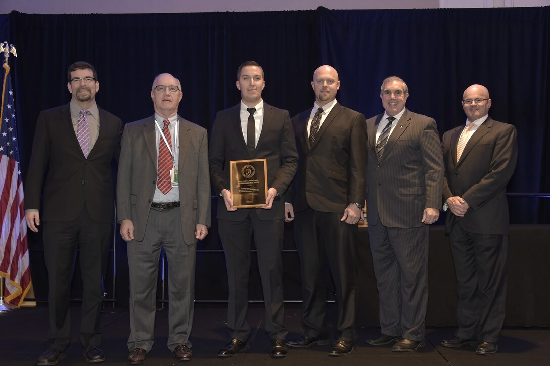 From left to right, David Freidman, former acting assistant secretary for the Office of Energy Efficiency and Renewable Energy presents the award to John Carson, former DLA Installation Support for Distribution site director; Andrew During, DLA energy manager; Ryan Taylor, DLA Installation Support for Distribution, general engineer; and Don Juhasz, DLA Installation Energy and Fire Protection chief, while Dr. Timothy Unruh, Department of Energy Federal Energy Management Program director, looks on.