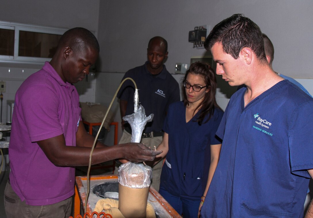Senegalese prosthesis technician Mamadou Kare, customizes a prosthetic limb for a patient as U.S. military medical professionals observe during Medical Readiness Training Exercise 17-1 at La Sante des Armees Hospital in Dakar, Senegal, Jan. 12, 2017. MEDRETE is a combined effort between the Senegalese government, U.S. Army Africa, the U.S. Army Reserve 332nd Medical Brigade in Nashville, Tenn., and the Vermont Air National Guard. AFRICOM’s MEDRETEs hosted by United States Army-Africa pair small teams of military medical professionals from the U.S. with participating African partner nations to train alongside and share best practices in trauma and surgical medicine. U.S. personnel; benefit by providing medical care in a forward and austere environment; African partners develop closer relations ships with medical personnel, and local populations receive additional medical care. (U.S. Army Africa photo by Maj. Simon Flake)
