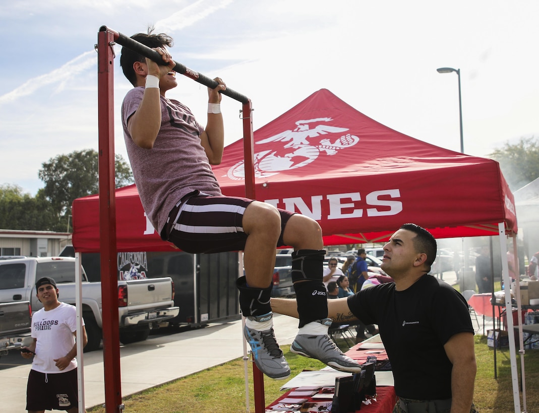 Cpl. Mario Miranda (Right) counts pull-ups for a high school wrestler at the Frankie Ramos JV Wrestling Tournament at Imperial High School, Imperial, Calif. on Jan. 7, 2017, The tournament was started six years ago to honor Frankie Ramos and celebrate his life as a successful wrestler and Marine. Ramos passed away while serving as a recruiting aid in Imperial on March 19, 2010. Miranda, from Imperial, Calif. is a warehouse clerk with Headquarters and Service Company, 4th Tank Battalion, 4th Marine Division. (U.S. Marine Corps photo by Sgt. William Hester/ Released)