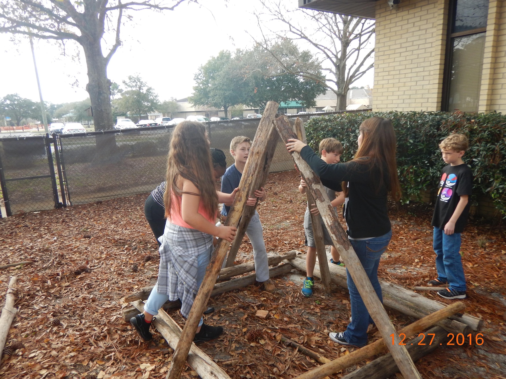 Hurlburt Field youth help build a wooden structure in the Nature Explore outdoor classroom at the youth center on Hurlburt Field, Fla., Dec. 27, 2016. The pre-teen youth, ages 9-12, had a first-hand experience in creating the areas giving them a sense of ownership of their outdoor classroom. (Courtesy Photo)