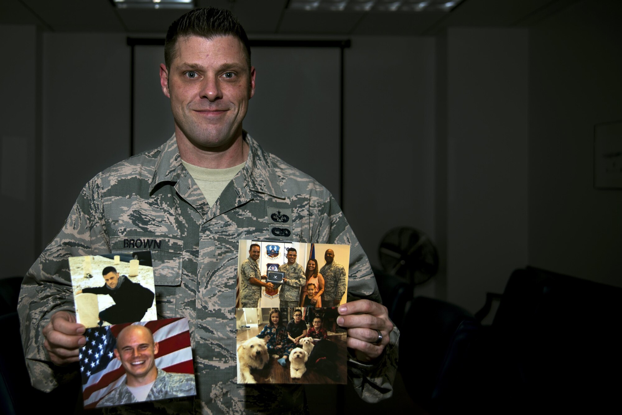 U.S. Air Force Tech. Sgt. Richard Brown, 20th Fighter Wing administrative law NCO in charge, holds photos of friends, family members, and life events which contribute to his personal resiliency at Shaw Air Force Base, S.C., Jan. 24, 2017. Brown uses what he has learned from his past experiences to help Team Shaw Airmen learn about resiliency. (U.S. Air Force photo by Airman 1st Class Kathryn R.C. Reaves)