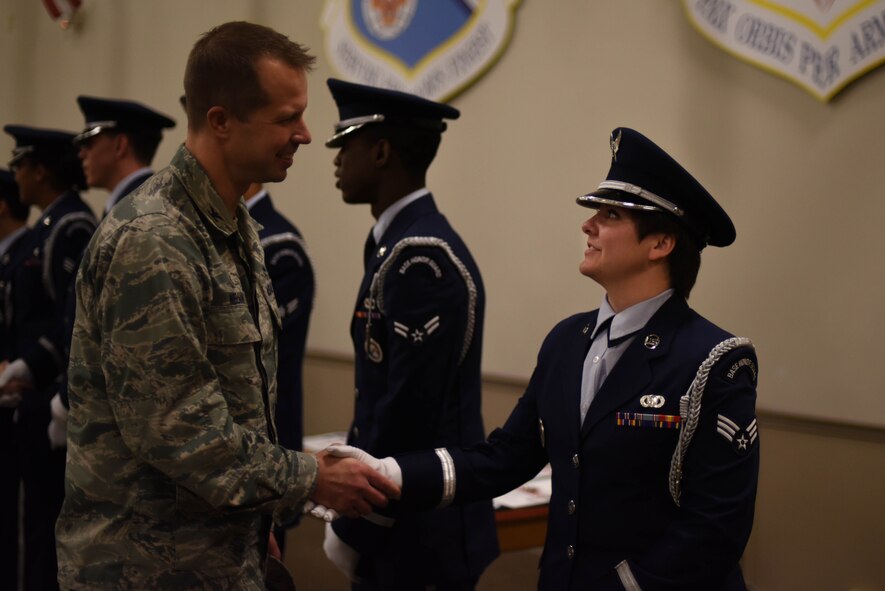 Col. Ty Nueman, 2nd Bomb Wing commander, congratulates Senior Airman Emily Boudreaux, 2nd Operation Support Squadron all source analyst, on becoming a member of the Barksdale honor guard at Barksdale Air Force Base, La., Jan. 23, 2017. Boudreaux will be honor guard full-time for three months, then be on the standby flight for another three months. (U.S. Air Force photo/Airman 1st Class Stuart Bright)