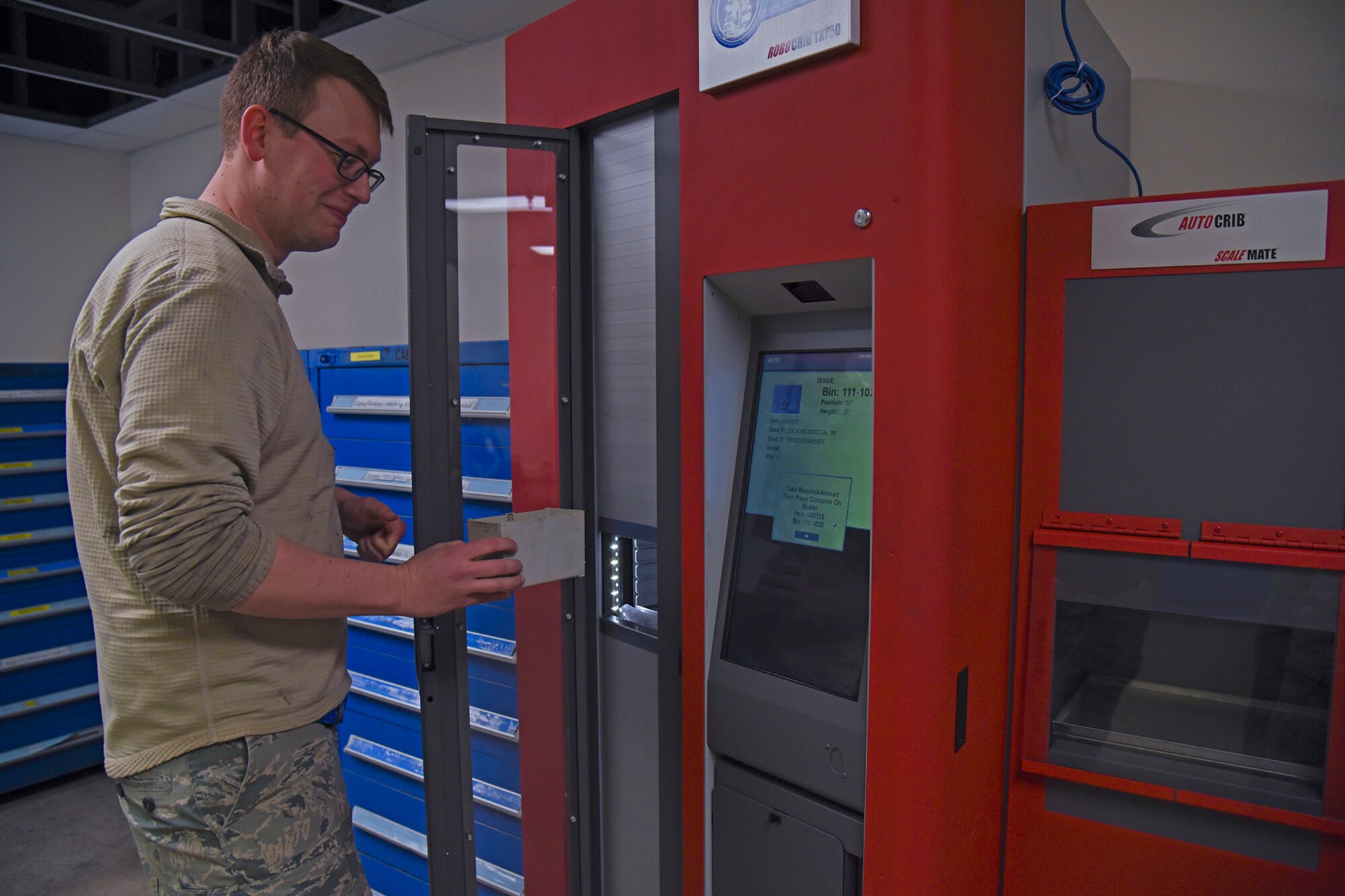 Senior Airman Paul Brockbank, 92nd Maintenance Squadron periodic inspection journeyman, removes a bin containing his desired fastener from the RoboCrib Jan. 20, 2017, at Fairchild Air Force Base, Wash. The RoboCrib maintains a digital catalog with images of every type of fastener. After selecting the desired product, the Airman then removes the desired amount and returns the bin. The RoboCrib then updates inventory automatically based on the new weight. (U.S. Air Force photo/Senior Airman Mackenzie Richardson)