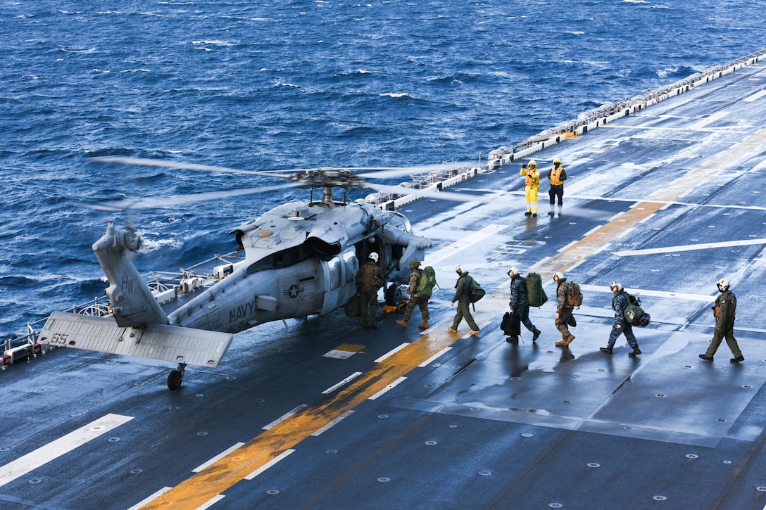 Sailors and Marines prepare to board an MH-60S Seahawk helicopter aboard the USS Bataan in the Atlantic Ocean, Jan. 23, 2017. The Bataan is conducting a composite training unit exercise to prepare for an upcoming deployment. Navy photo by Petty Officer 1st Class Julie R. Matyascik