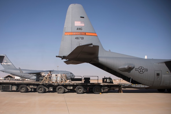 Aerial porters from the 870th Air Expeditionary Squadron push a pallet of supplies from a K-loader into the back of a C-130H Hercules at Al Asad Air Base, Iraq, Jan. 9, 2017. Aerial porters are responsible for loading and unloading aircraft and moving cargo around the cargo yard. (U.S. Air Force photo/Senior Airman Andrew Park)