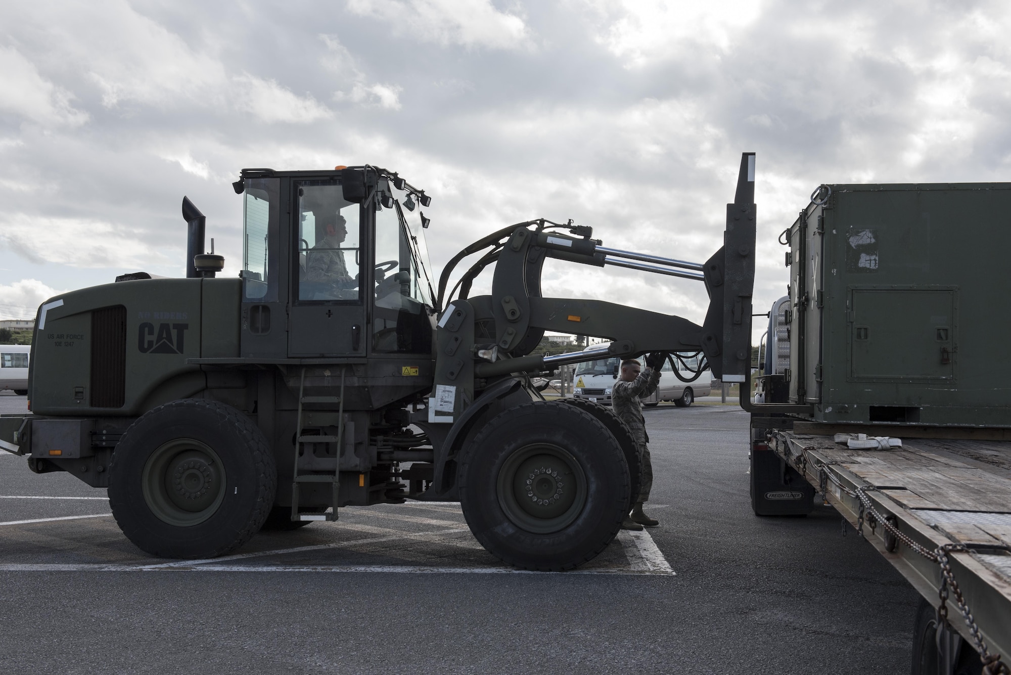 U.S. Air Force Airman 1st Class Jonathan Book, 18th Logistics Readiness Squadron vehicle operator, removes cargo containers from the back of a tractor-trailer using a 10k all-terrain vehicle Jan. 19, 2017, at a vehicle depot on Kadena Air Base, Japan. Vehicle operators are trained to recover wrecked vehicles and move heavy equipment in specialized vehicles. (U.S. Air Force photo by Senior Airman Omari Bernard/Released)