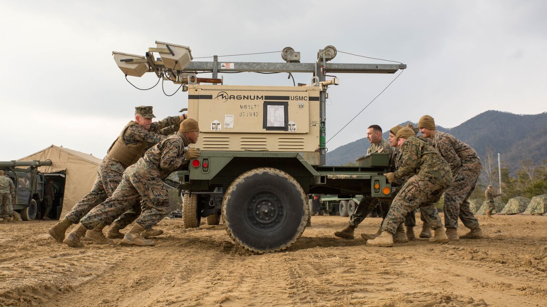 U.S. Marines with Marine Wing Support Squadron 171 move a flood light through the mud during exercise Kamoshika Wrath 17-1 at Japan Ground Self-Defense Force’s Haramura Maneuver Area in Hiroshima, Japan, Jan. 22, 2017. The exercise is a biannual, unit-level training exercise that is primarily focused on establishing a forward operating base and providing airfield operation services. MWSS-171 trains throughout the year completing exercises like Kamoshika Wrath 17-1 to enhance their technical skills, field experience and military occupational specialty capability. 