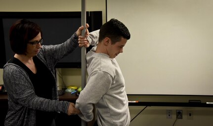 Patrice Hickey, exercise physiologist, 70th Intelligence, Surveillance and Reconnaissance Wing, prepares an Airman for an inline lounge Jan. 25 at Fort George G. Meade, Maryland. The inline lounge is one of the seven movement assessments during a Functional Movement Screen, which is part of the Meeting Mission Objectives via Exercises (MOVE) program. FMS uses seven different assessments to identify weak and improper movement patterns. (U.S. Air Force photo/Staff Sgt. AJ Hyatt)