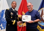 Army Brig. Gen. Charles Hamilton, DLA Troop Support Commander, presents photographer Ed Maldonado with a commander's coin and certificate of appreciation during a quarterly awards ceremony Jan. 12.