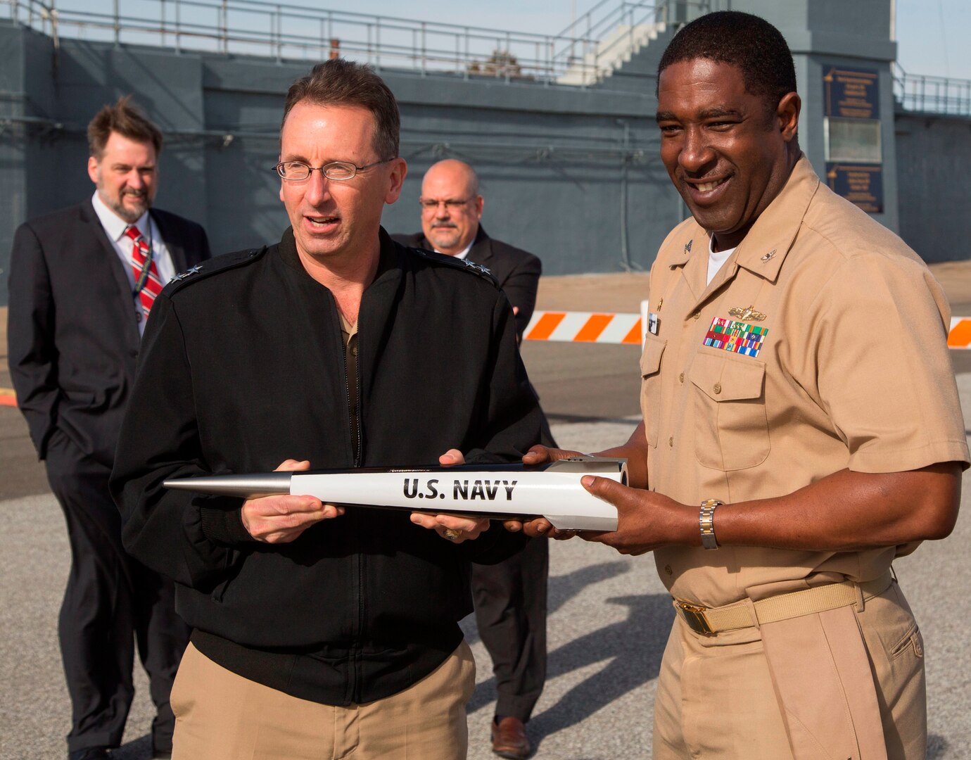 DAHLGREN, Va. - Rear Admiral David Hahn, chief of naval research, and Capt. Godfrey "Gus" Weekes, NSWCDD commanding officer, hold an electromagnetic railgun projectile during Hahn's visit to NSWCDD, Jan. 12. The admiral led his Office of Naval Research (ONR) delegation to see new and emerging ONR sponsored technologies developed at NSWCDD, including directed energy and the electromagnetic railgun. They also watched engineers fire a hypervelocity projectile from a 5-inch, 62-caliber open mount gun at the Potomac River Test Range. (U.S. Navy photo by Ryan DeShazo/Released)