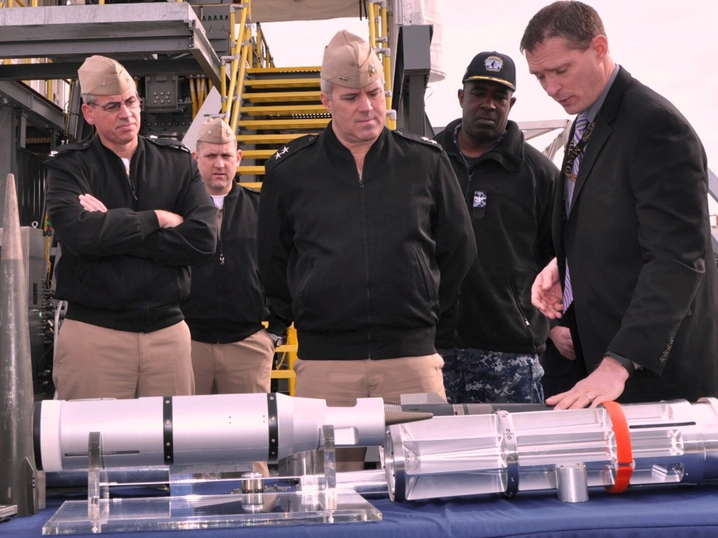 DAHLGREN, Va. - Adam Jones, a Naval Surface Warfare Center Dahlgren Division (NSWCDD) engineer, briefs Rear Adm. Ronald Boxall, director of Surface Warfare (OPNAV N96), on electromagnetic railgun projectiles, Jan 19. Navy officials believe Boxall's NSWCDD tour will boost coordination and information sharing to support integrated warfighting assessment. The admiral led his delegation from the Office of the Chief of Naval Operations to see new and emerging technologies developed at NSWCDD that included directed energy, electromagnetic railgun, hypervelocity projectile, cyber security, Tactical Tomahawk missile, mission engineering, and the Combined Integrated Air & Missile Defense/Antisubmarine Warfare Trainer.  (U.S. Navy photo by John Joyce/Released)