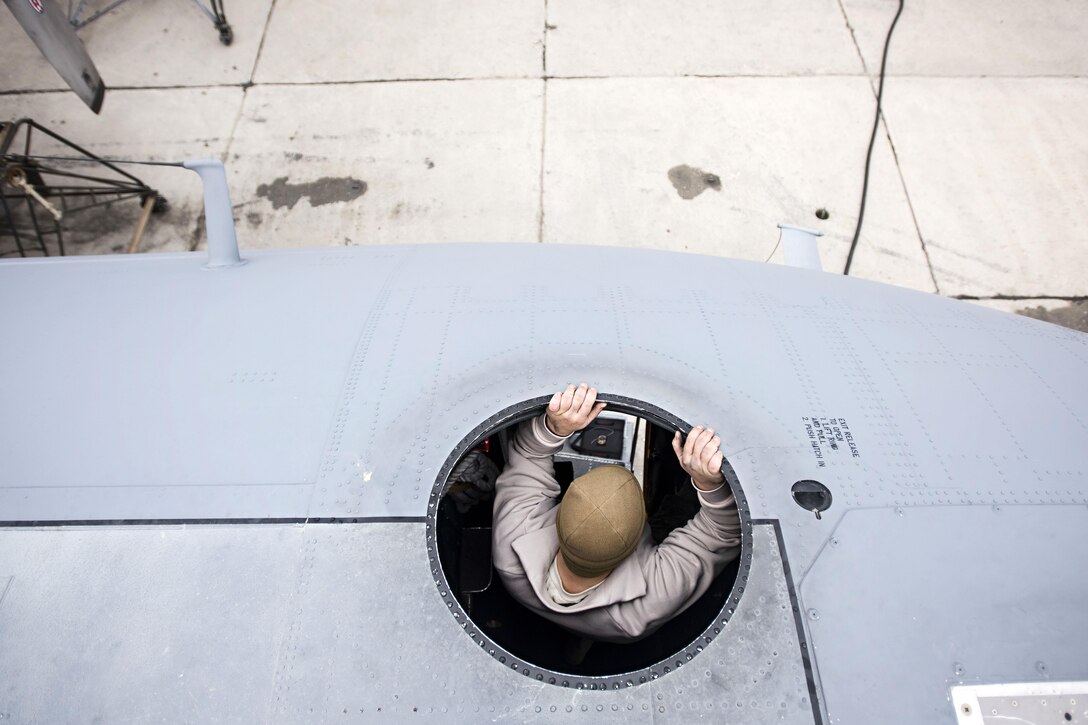 Air Force Staff Sgt. Sean Nelson lowers himself off the roof of an EC-130 Compass Call aircraft during scheduled maintenance at Bagram Airfield, Afghanistan, Jan. 18, 2017. Nelson is assigned to the 455th Expeditionary Aircraft Maintenance Squadron. Air Force photo by Staff Sgt. Katherine Spessa