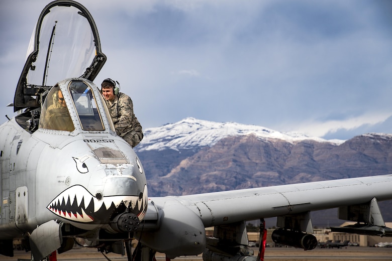 Airman 1st Class Devin Moore, right, 74th Aircraft Maintenance Unit avionics technician, speaks with a fellow maintainer while conducting maintenance on an A-10C Thunderbolt II during Green Flag-West 17-03, Jan. 23, 2017, at Nellis Air Force Base, Nev. GFW is an air-land integration combat training exercise, which hosted 12 A-10s from Moody Air Force Base, Ga. Accompanying the aircraft were 130 maintenance personnel who worked around the clock to launch 18 sorties per day. (U.S. Air Force photo by Staff Sgt. Ryan Callaghan)