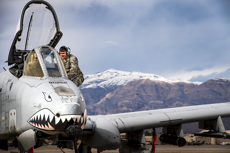 Airman 1st Class Devin Moore, right, 74th Aircraft Maintenance Unit avionics technician, speaks with a fellow maintainer while conducting maintenance on an A-10C Thunderbolt II during Green Flag-West 17-03, Jan. 23, 2017, at Nellis Air Force Base, Nev. GFW is an air-land integration combat training exercise, which hosted 12 A-10s from Moody Air Force Base, Ga. Accompanying the aircraft were 130 maintenance personnel who worked around the clock to launch 18 sorties per day. (U.S. Air Force photo by Staff Sgt. Ryan Callaghan)