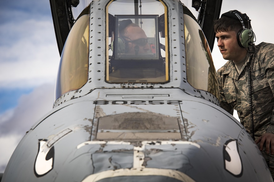 Airman 1st Class Devin Moore, right, 74th Aircraft Maintenance Unit avionics technician, speaks with a fellow maintainer while conducting maintenance on an A-10C Thunderbolt II during Green Flag-West 17-03, Jan. 23, 2017, at Nellis Air Force Base, Nev. GFW is an air-land integration combat training exercise, which hosted 12 A-10s from Moody Air Force Base, Ga. Accompanying the aircraft were 130 maintenance personnel who worked around the clock to launch 18 sorties per day. (U.S. Air Force photo by Staff Sgt. Ryan Callaghan)
