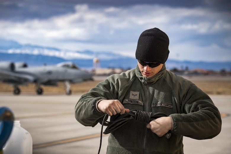 Senior Airman Eric Hinton, 74th Aircraft Maintenance Unit crew chief, wraps a communications cord as an A-10C Thunderbolt II taxis to the flightline during Green Flag-West 17-03, Jan. 23, 2017, at Nellis Air Force Base, Nev. GFW is an air-land integration combat training exercise, which hosted 12 A-10s from Moody Air Force Base, Ga. Accompanying the aircraft were 130 maintenance personnel who worked around the clock to launch 18 sorties per day. (U.S. Air Force photo by Staff Sgt. Ryan Callaghan)