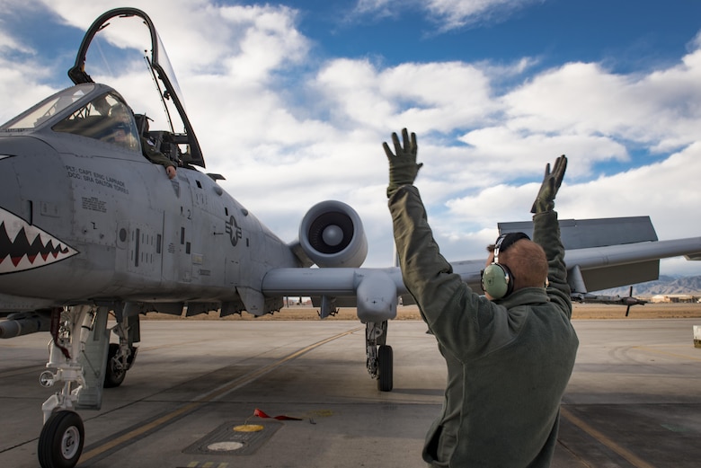 Senior Airman Cody Campbell, 74th Aircraft Maintenance Unit crew chief, marshals an A-10C Thunderbolt II to a parking spot during Green Flag-West 17-03, Jan. 23, 2017, at Nellis Air Force Base, Nev. GFW is an air-land integration combat training exercise, which hosted 12 A-10s from Moody Air Force Base, Ga. Accompanying the aircraft were 130 maintenance personnel who worked around the clock to launch 18 sorties per day. (U.S. Air Force photo by Staff Sgt. Ryan Callaghan)