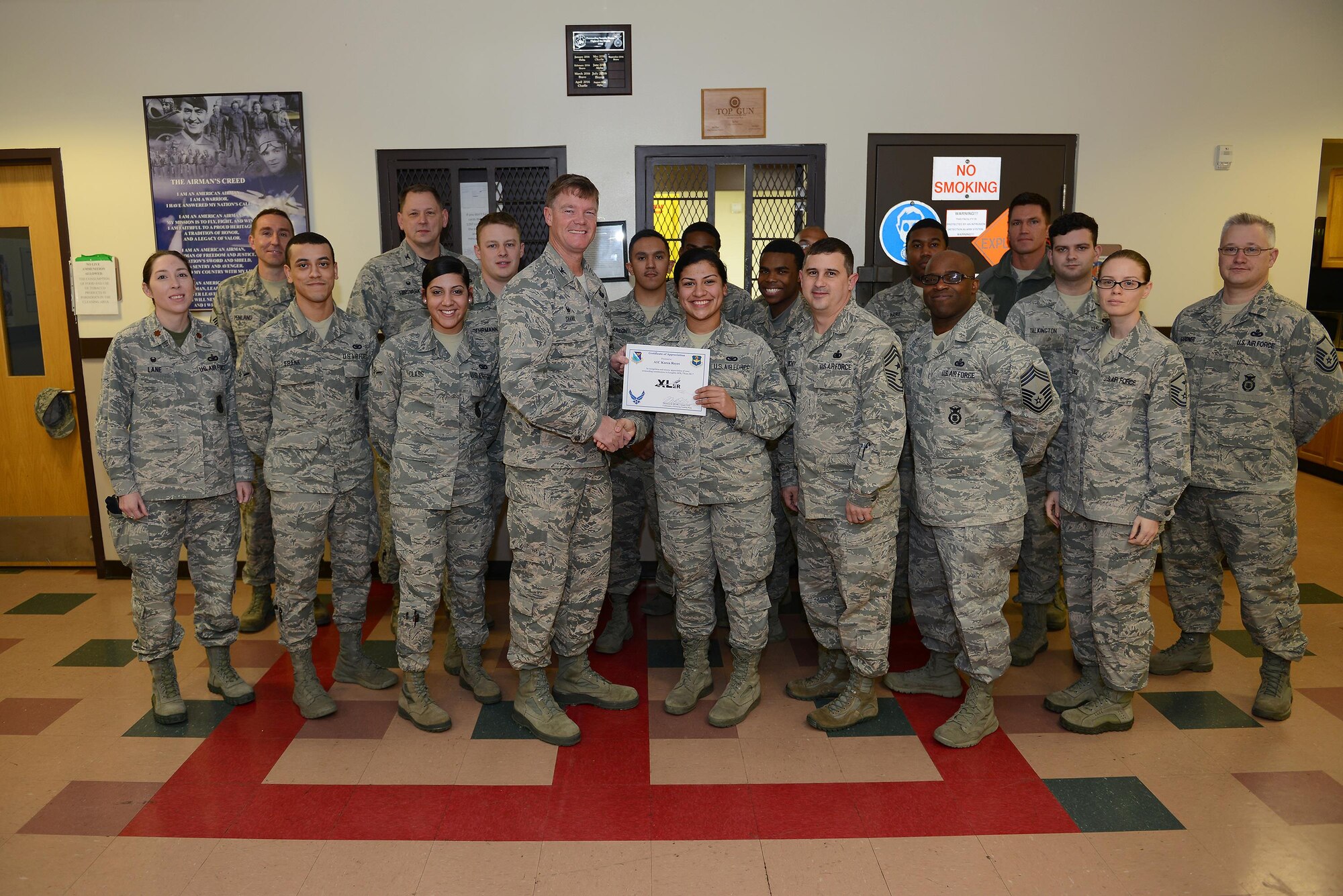 Airman 1st Class Karen Reyes, 47th Security Forces Squadron patrolman (front center), accepts the “XLer of the Week” award from Col. Thomas Shank, 47th Flying Training Wing commander (front left), and Chief Master Sgt. George Richey, 47th FTW command chief (front right), on Laughlin Air Force Base, Texas, Jan. 19, 2017. The XLer is a weekly award chosen by wing leadership and is presented to those who consistently make outstanding contributions to their unit and Laughlin. (U.S. Air Force photo/Airman 1st Class Benjamin N. Valmoja)