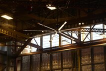 A new fan is shown circulating warm air downwards inside of Hangar 285 Jan. 20, 2017, at Altus Air Force Base Oklahoma. The new fans improve air circulation in hangars and aim to keep the maintenance working conditions safe, controlling health and temperature concerns and enabling the maintainers to work on aircraft year-round. (U.S. Air Force photo by Airman 1st Class Cody Dowell/released)