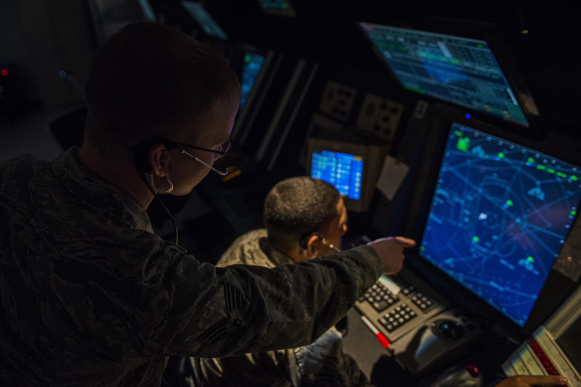Two 27th Special Operations Support Squadron Air Traffic Controllers assigned to Radar Approach Control view a display screen showing aircraft in the surrounding airspace Jan. 6, 2017, at Cannon Air Force Base, N.M. The RAPCON team is responsible for the airspace stretching approximately 60 miles in each direction of the base and ranges from the surface up to 17,000 ft. (U.S. Air Force photo by Senior Airman Luke Kitterman/Released) 
 
