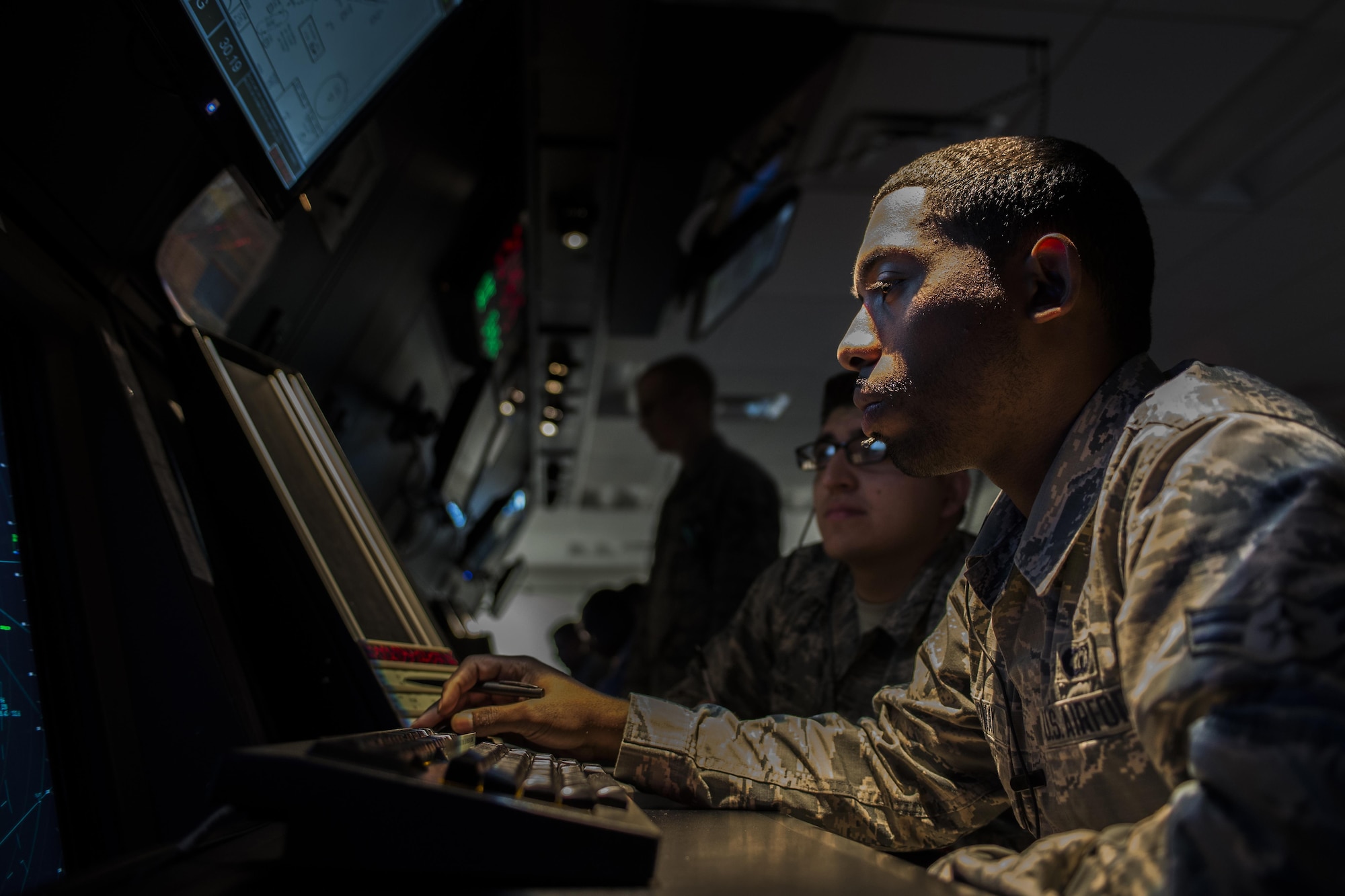 Two 27th Special Operations Support Squadron Air Traffic Controllers assigned to Radar Approach Control view a display screen showing aircraft in the surrounding airspace Jan. 6, 2017, at Cannon Air Force Base, N.M. The RAPCON team is responsible for any air craft in their airspace including non-military flights coming from nearby air traffic facilities, also known as overflights. (U.S. Air Force photo by Senior Airman Luke Kitterman/Released) 