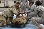 Flight paramedics from the 1st Battalion, 228th Aviation Regiment assist Joint Security Forces personnel with patient packaging as part of the hot and cold load orientation during a Medical Evacuation training, at Soto Cano Air Base, Jan. 17, 2017. 