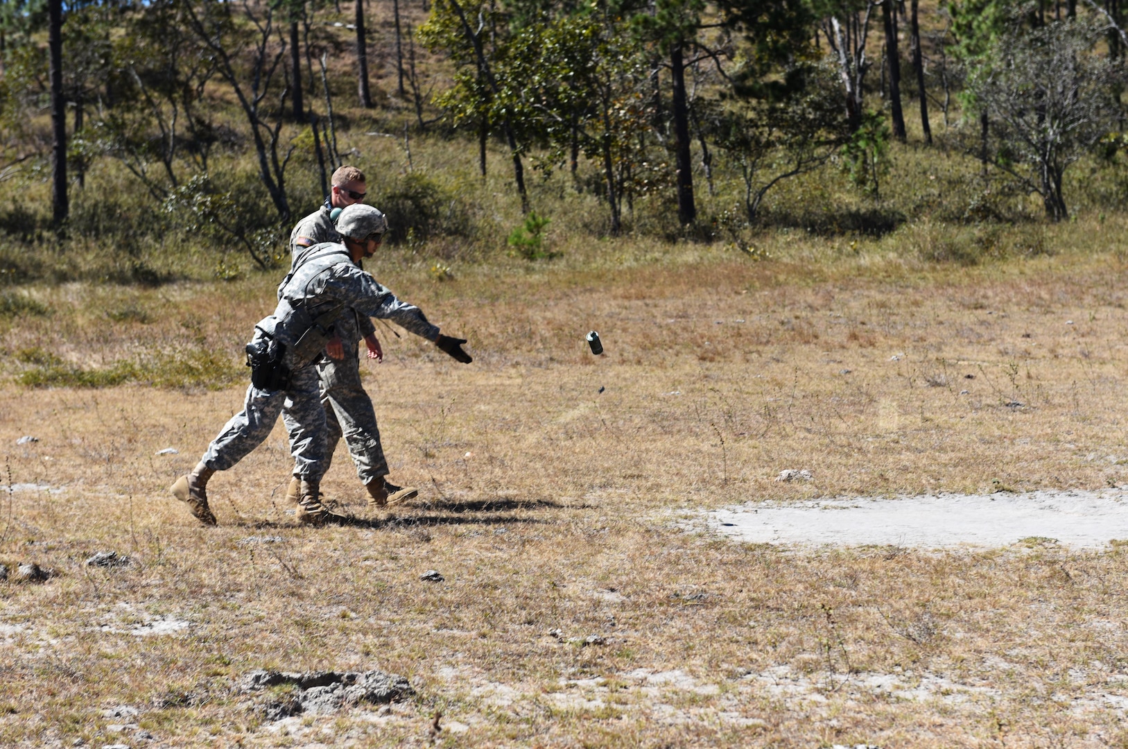 A service member assigned to Joint Task Force- Bravo’s Joint Security Forces throws a smoke canister that will mark the landing zone for a UH-60 helicopter as part of a joint Medical Evacuation training exercise between JSF and the 1st Battalion, 228th Aviation Regiment, near Soto Cano Air Base, Honduras, Jan. 18, 2017. 