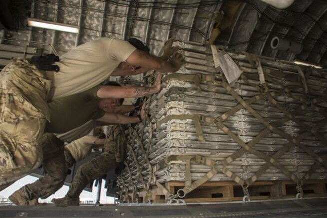 386th Air Expeditionary Wing Public Affairs - Aerial porters, a loadmaster, and a Marine all work together to push a pallet into the cargo area of a C-17 Globemaster III at Al Asad Air Base, Iraq, Jan. 9, 2017. Austere locations can often be minimally manned so members must work across sections and sometimes even branches to help get the job done. 