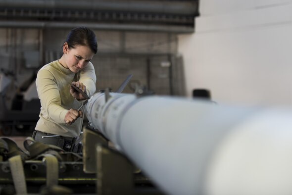 Airman 1st Class Gina Herringer-Koblack, 52nd Aircraft Maintenance Squadron tactical aircraft weapons system specialist, prepares an inert weapon for loading during the annual weapons load competition in Hangar One at Spangdahlem Air Base, Germany, Jan. 20, 2016. The competition featured two teams competing for the wing’s best load crew. Additionally, the winning team’s completion time will be compared to other squadrons in the Major Command to determine the best load crew in United States Air Forces in Europe. The wing winner will be announced at the Maintenance Professional of the Year banquet March 10, 2016. (U.S. Air Force photo by Airman 1st Class Preston Cherry)