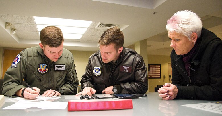 Capt. Erik “Speedy” Gonsalves, U.S. Air Force Thunderbirds advance pilot/narrator, and Capt. Michael Knapp, 3rd Airlift Squadron pilot, center, prepare a departure flight plan, Jan. 25, 2017, at base operations on Dover Air Force Base, Del. Dawne Nickerson-Banez, 436th Airlift Wing Public Affairs community engagement chief, coordinated support for a site survey of Dover’s airfield in preparation for the scheduled “Thunder Over Dover: 2017 Dover AFB Open House,” August 26 and 27. (U.S. Air Force photo by Roland Balik)