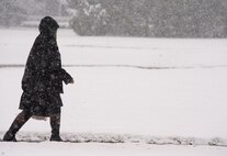 A woman makes her way to the parking lot outside of the Air Force Material Command headquarters building through falling snow on Wright-Patterson Air Force Base, Ohio, Dec. 13, 2016. The first significant snowfall of the season delivered four inches of snow to blanket the area. (U.S. Air Force photo by R.J. Oriez/Released)