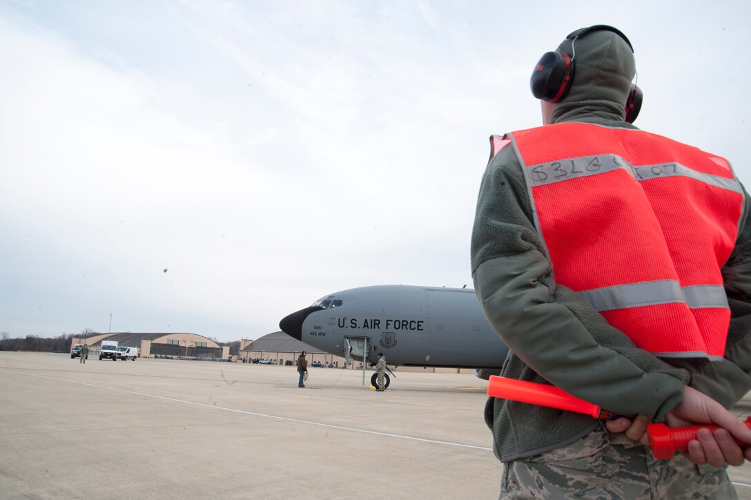 Senior Airman Jaramie York, 459th Aircraft Maintenance Squadron maintainer, awaits approval to marshal a KC-135R Stratotanker down the runway at Joint Base Andrews, Md., Dec. 13, 2016. The aircraft burns approximately 10,000 pounds of fuel during a typical four-hour mission when its four engines are running. (U.S. Air Force photo by Staff Sgt. Joe Yanik)