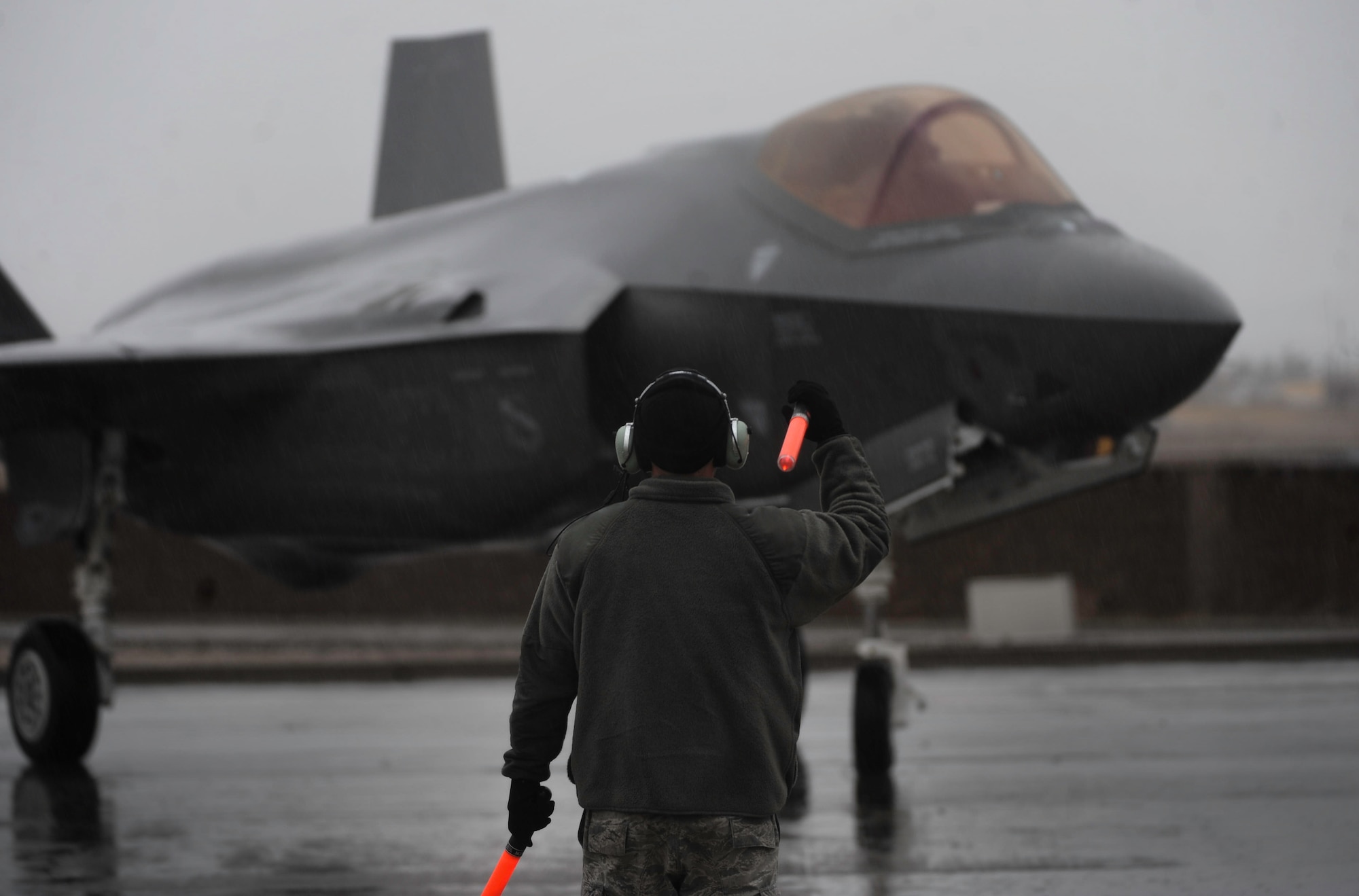 A crew chief, assigned to the 34th Fighter Squadron, Hill Air Force Base, Utah, marshals an F-35A Lightning II after landing on Nellis Air Force Base, Nev., Jan. 21, 2017. The F-35A will be participating in Red Flag 17-1, making it the first iteration to incorporate the fifth generation fighter. (U.S. Air Force photo by Airman 1st Class Kevin Tanenbaum/Released)