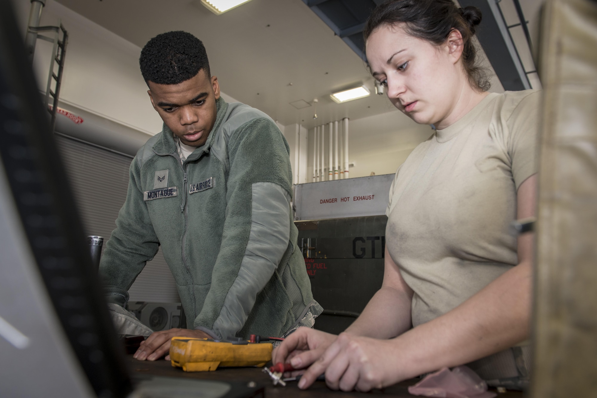 U.S. Air Force Senior Airman Shaquille Montague, left, a firefighter with the 35th Civil Engineer Squadron, watches as Senior Airman Kelci Vo, an aerospace ground equipment journeyman with the 35th Maintenance Squadron, charges a diode for a M32A-60A gas turbine generator during Misawa’s first-ever career field exchange and shadow program at Misawa Air Base, Japan, Jan. 26, 2017. The generator is a 35th MXS AGE flight asset used to troubleshoot F-16 Fighting Falcons prior to takeoff. Montague joined five other Airmen who took part in Misawa’s first-ever career field exchange and shadow program. The initiative affords service members of all ranks from across the installation an opportunity to live a day in another’s boots. (U.S. Air Force photo by Staff Sgt. Benjamin W. Stratton)