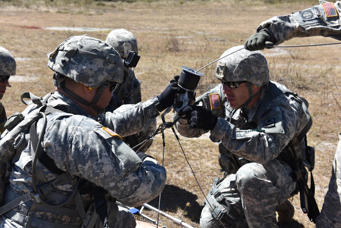 Personnel from Joint Task Force-Bravo Joint Security Forces practice securing a stretcher prior to hoisting a simulated patient onto a helicopter during a joint Medical Evacuation  training between JSF and the 1st Battalion, 228th Aviation Regiment, near Soto Cano Air Base, Honduras, Jan. 18, 2017.