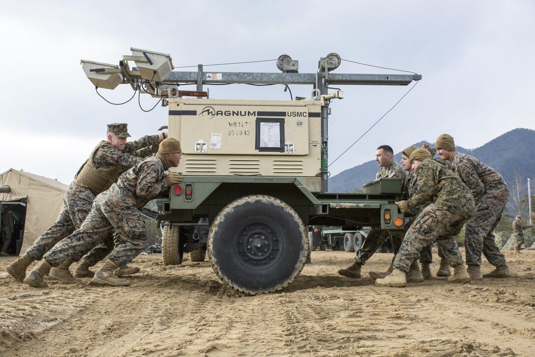 Marines move a floodlight through the mud during exercise Kamoshika Wrath 17-1 at the Japan Ground Self-Defense Force’s Haramura Maneuver Area in Hiroshima, Japan, Jan. 22, 2017. The exercise focuses on airfield operation services. Marine Corps photo by Cpl. Donato Maffin