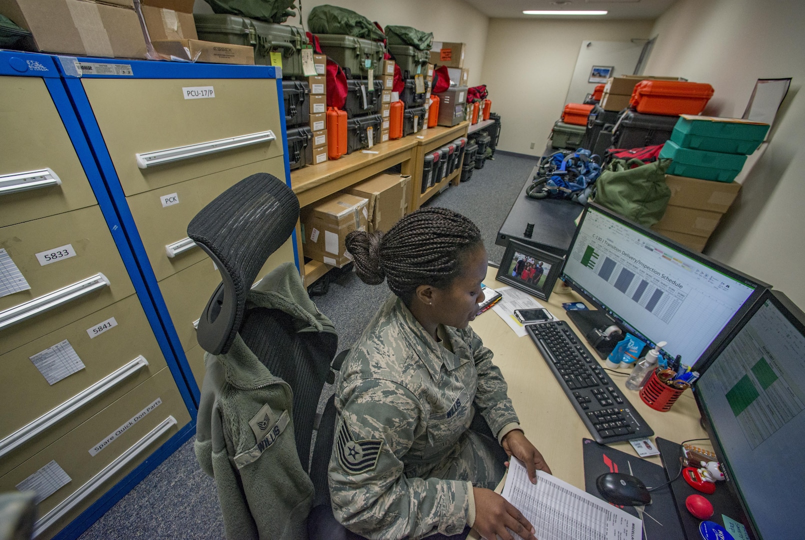 Tech Sgt. Shakuntala M. Willis, 374th Operations Support Squadron Aircrew Flight Equipment flight NCO in charge of the C-130J transition, works at her desk surrounded by the survival and life-support equipment she is in charge of Jan. 25, 2017, at Yokota Air Base, Japan. The AFE flight has been preparing aircrew survival and life-support equipment for the arrival of the new C-130J Super Hercules since May 2016. (U.S. Air Force photo by Airman 1st Class Donald Hudson)