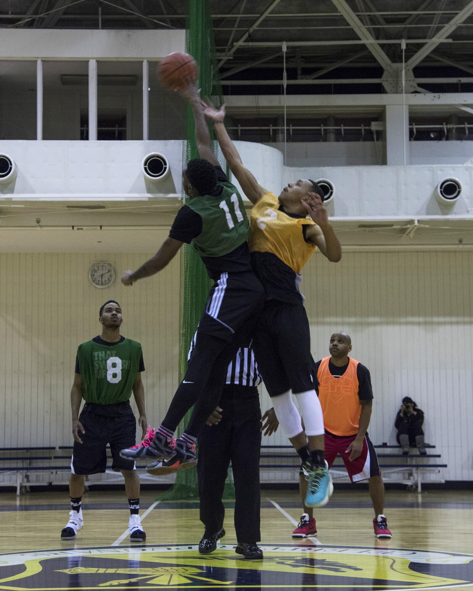 Jarvis Hodges, 374th Maintenance Squadron, taps the ball to a teammate over Austin Ludden, 374th Communications Squadron, at the beginning of an intramural basketball game at Yokota Air Base, Japan, Jan. 24, 2017. The 374 MXS team won the game 46-40 giving them a 1-0 record for the season. (U.S. Air Force photo by Staff Sgt. David Owsianka)