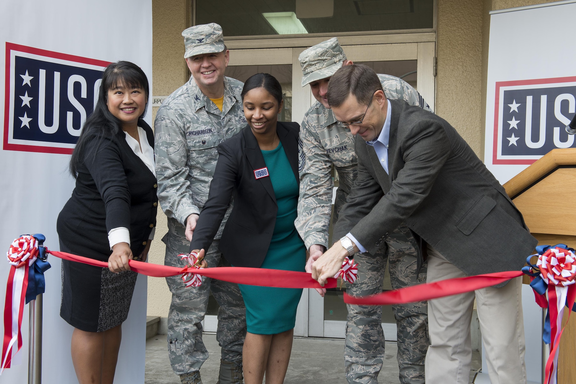 Members of the United Service Organizations and 374th Airlift Wing leadership cut the ribbon during the USO center grand opening at Yokota Air Base, Japan, Jan. 27, 2017. The USO was founded by Theodore Roosevelt on Feb. 4, 1941. (U.S. Air Force photo by Senior Airman David C. Danford)
