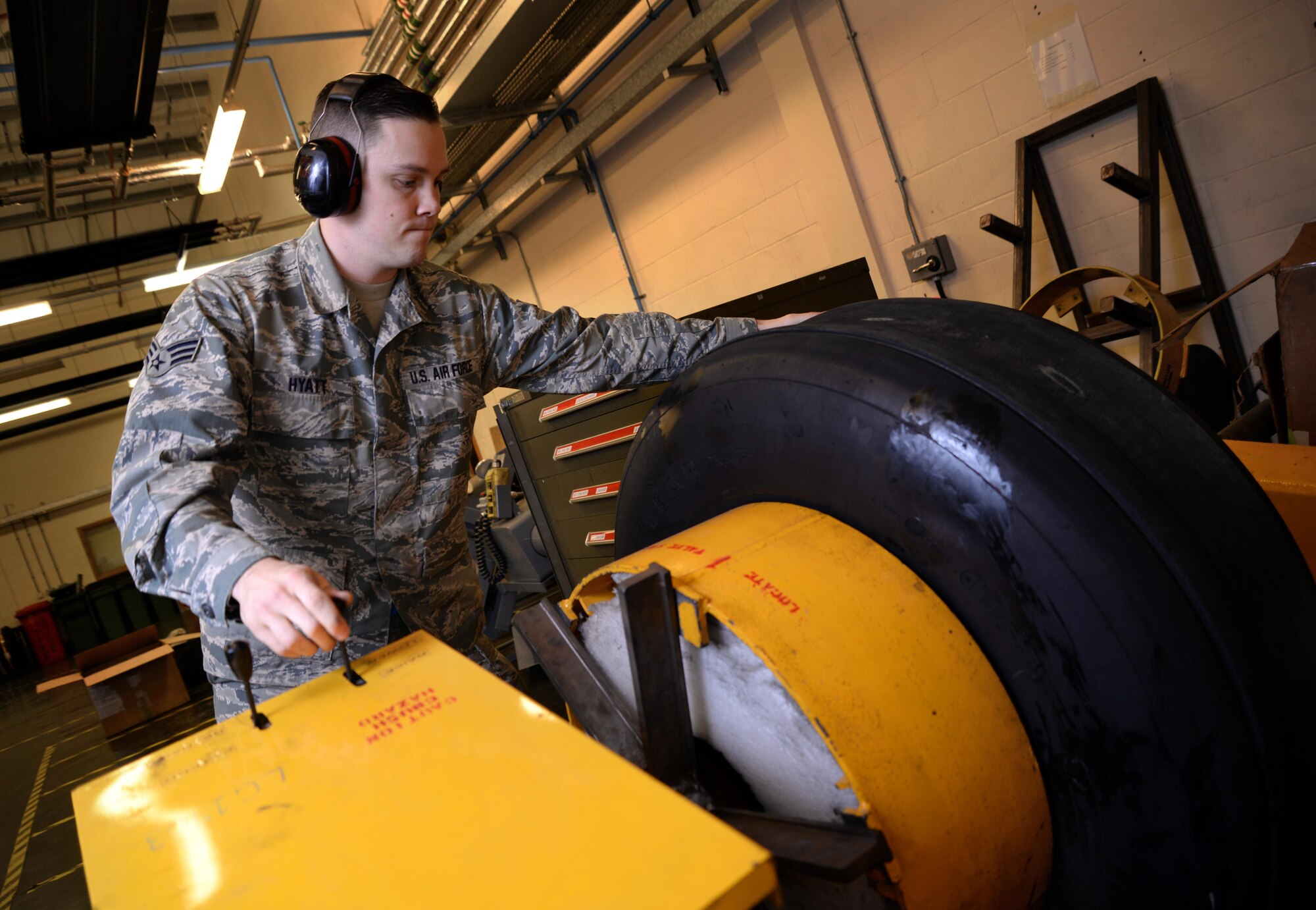 U.S. Air Force Senior Airman Tyler Hyatt, 100th Maintenance Squadron aero repair journeyman, places a tire into a bead breaker Jan. 20, 2017, on RAF Mildenhall, England. The bead breaker breaks two beads which connect the tire and wheel. (U.S. Air Force photo by Senior Airman Christine Halan)
