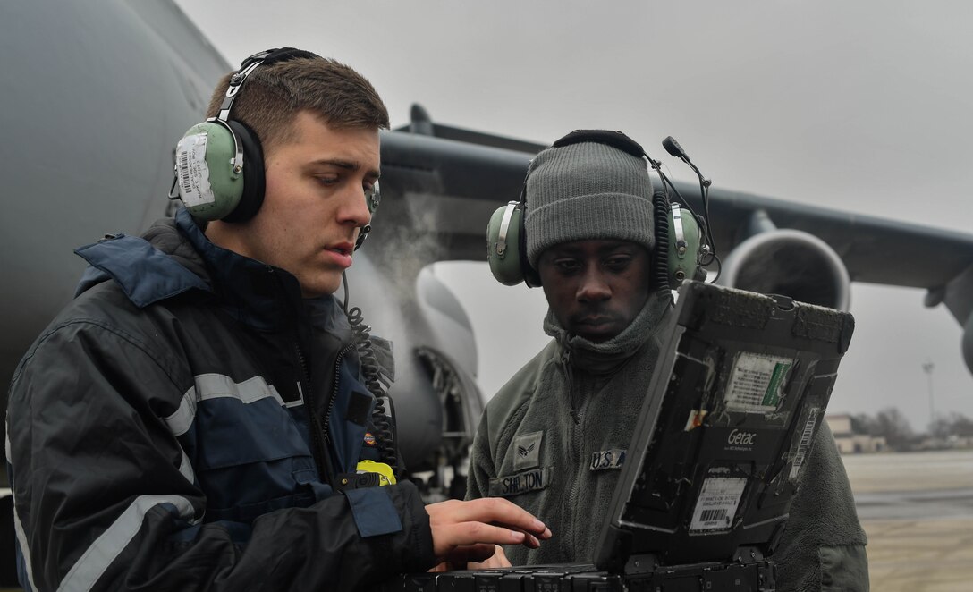 Staff Sgt. Zachary Rodewig, 721st Aircraft Maintenance Squadron C-5 Galaxy crew chief, explains the different aspects of maintenance for a C-5 aircraft to Senior Airman Earl Shelton, 721st AMXS aerospace maintenance technician, at Ramstein Air Base, Germany, Jan. 24, 2017. All Airmen within the 721st AMXS must be qualified on C-17 Globemaster III and C-5 aircraft. On average, the 721st AMXS inspects, services, and repairs 30 aircraft in a single day, as part of the 521st Air Mobility Operations Wing at Ramstein. (U.S. Air Force photo by Senior Airman Tryphena Mayhugh)