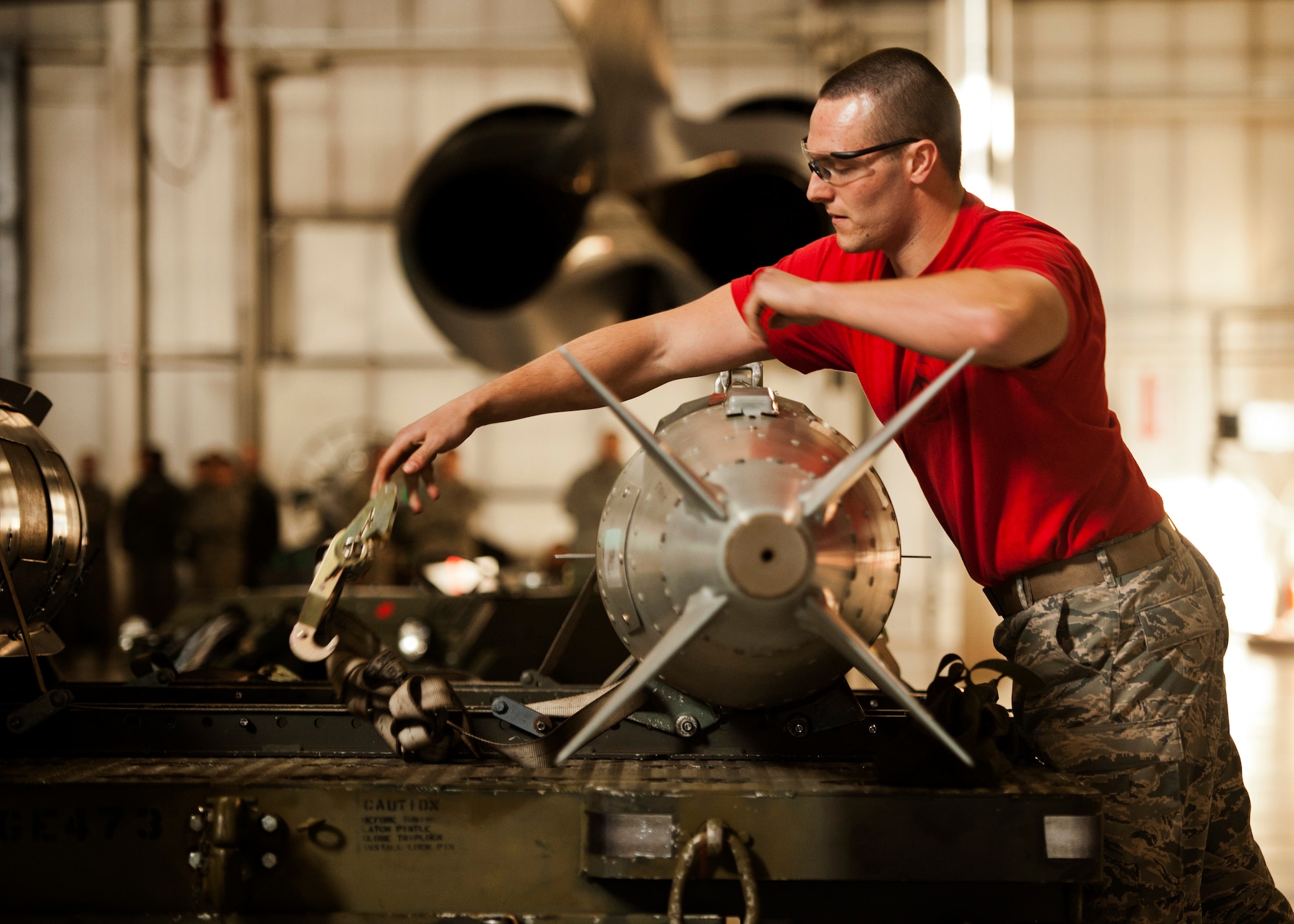 Senior Airman Nicholas George, 23rd Aircraft Maintenance Unit weapons load crew member, removes a strap from an inert GBU-31 at Minot Air Force Base, N.D., Jan. 20, 2017. The 23rd and 69th AMU competed in a timed bomb load as a part of the Load Crew of the Quarter competition. (U.S. Air Force photo/Airman 1st Class J.T. Armstrong)