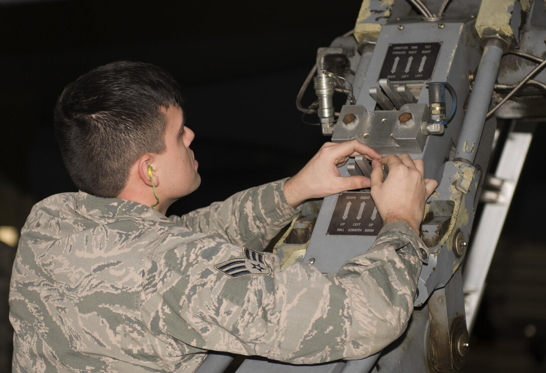 Senior Airman Brian Sanchez, 69th Aircraft Maintenance Unit weapons load crew member, lifts an inert munition onto a B-52H Stratofortress during the 5th Bomb Wing Load Crew of the Quarter competition in Dock 7 at Minot Air Force Base, N.D., Jan. 20, 2017. Two weapons load crews representing the 23rd Aircraft Maintenance Unit and the 69th AMU were timed on their ability to load two inert munitions onto a B-52H Stratofortress. (U.S. Air Force photo/Airman 1st Class Alyssa M. Akers)