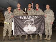 The weapons load crew representing the 23rd Aircraft Maintenance Unit in the 5th Bomb Wing Load Crew of the Quarter competition hold their award for winning the 5th Bomb Wing Load Crew of the Quarter competition in Dock 7 at Minot Air Force Base, N.D., Jan. 20, 2017. The competition was comprised of four parts: dress and appearance, a loader’s knowledge test, toolbox inspection and the timed bomb load. (U.S. Air Force photo/Airman 1st Class Alyssa M. Akers)