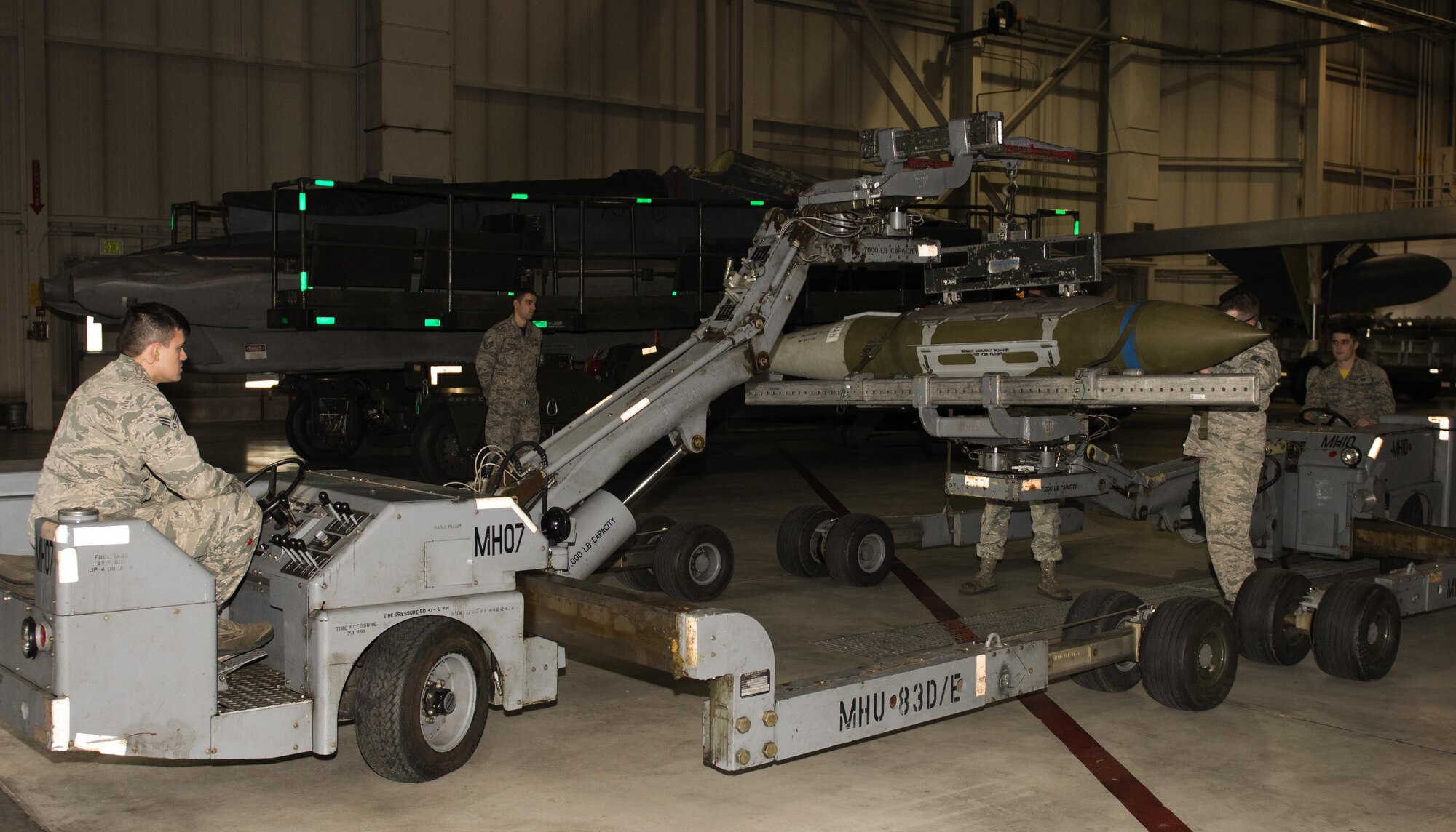 A team representing the 69th Air Maintenance Unit in the 5th Bomb Wing Loadcrew of the Quarter competition prepare to transport an inert munition to a B-52H Stratofortress during the 5th Bomb Wing Load Crew of the Quarter competition in Dock 7 at Minot Air Force Base, N.D., Jan. 20, 2017. The 23rd and 69th AMU competed in a timed bomb load as a part of the Load Crew of the Quarter competition. (U.S. Air Force photo/Airman 1st Class Alyssa M. Akers)