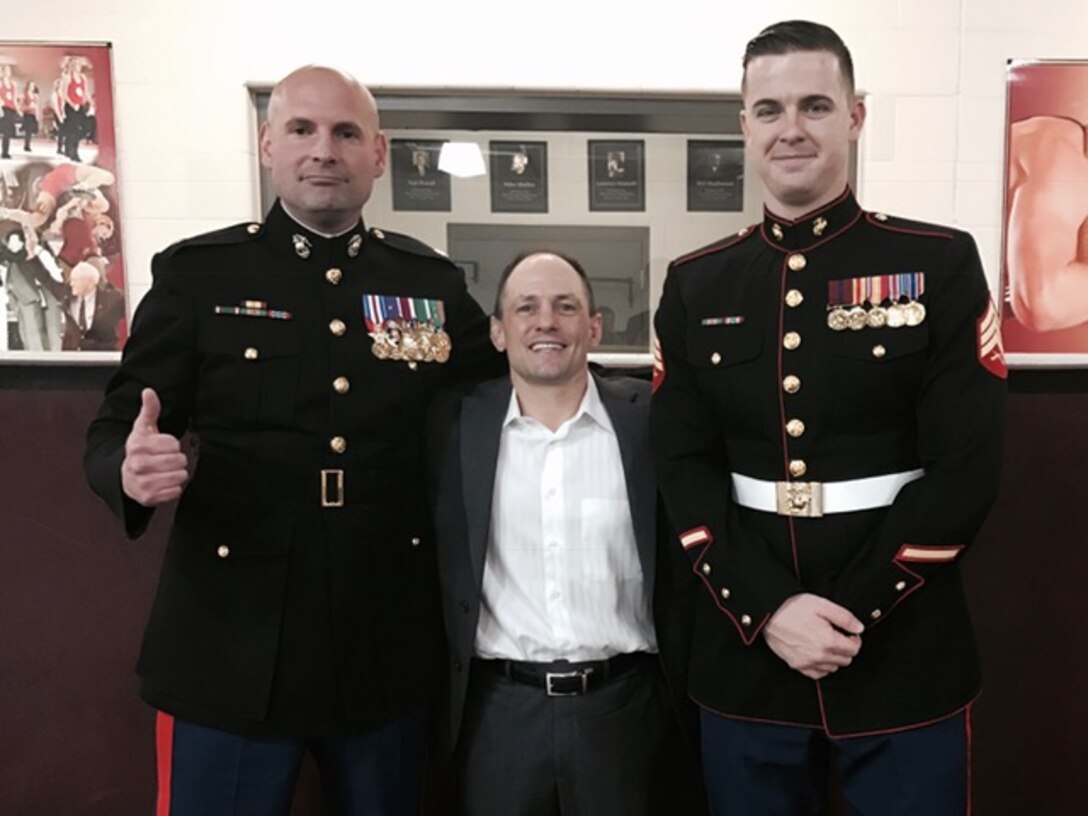 Maj. Ryan Cohen, the commanding officer for Recruiting Station Oklahoma City, and Sgt. Riley Saunders, a canvassing recruiter for Recruiting Substation Oklahoma City North,  pose for a photo with University of Oklahoma Wrestling Head Coach Lou Rosselli before their match against West Virginia, Jan. 22, 2017, at McCasland Field House, Norman, Okla. Cohen gave a motivational speech to the 14th-ranked Sooners wrestling team before they went on to defeat their opponent 37 to 6.