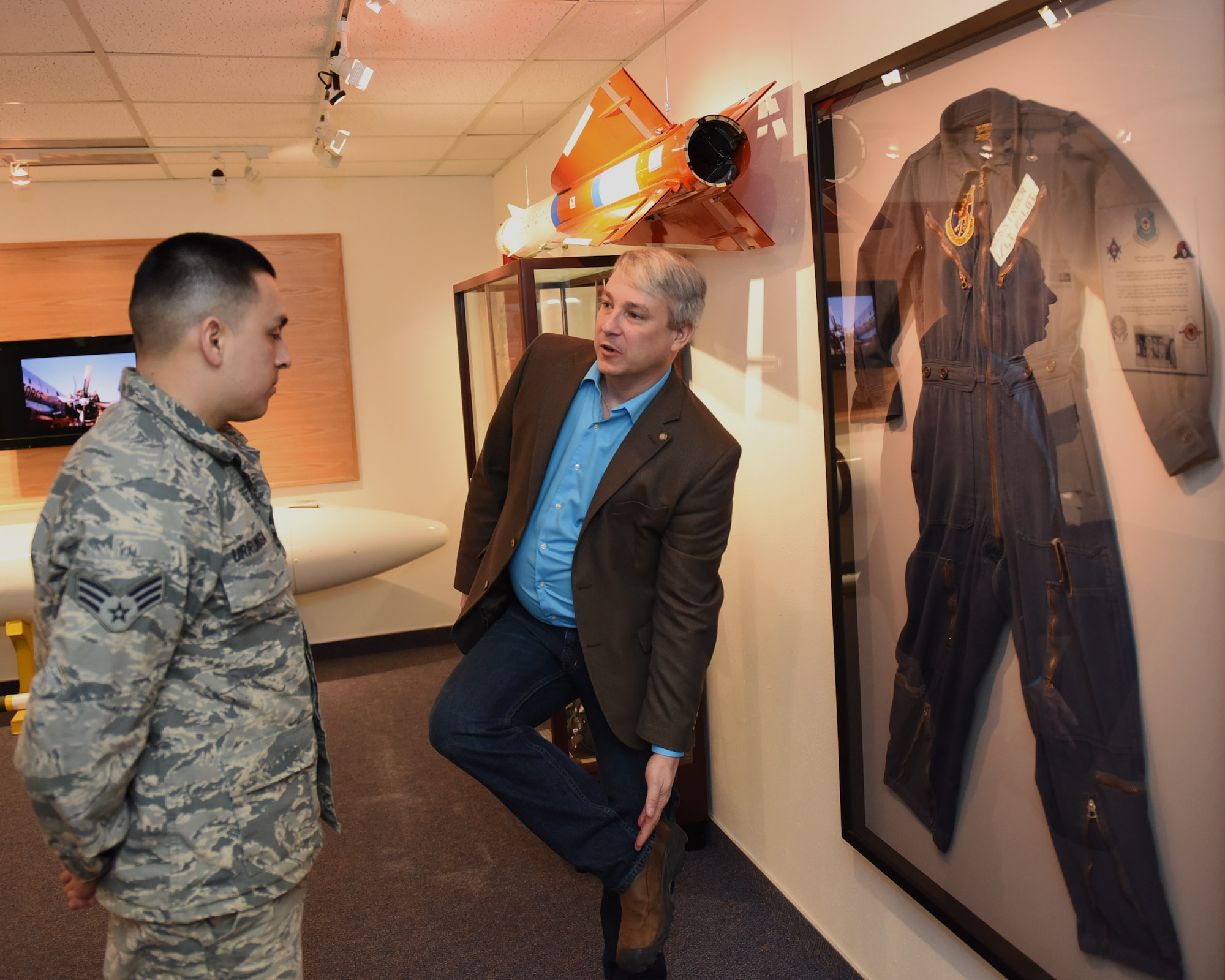 Senior Airman Valverde Urrunaga, 341st Civil Engineer Squadron Water & Fuels Systems Maintenance gets a history lesson about the missileer uniforms from Rob Turnbow, the Malmstrom Historic Exhibit and Air Park curator, Jan. 26, 2017 at Malmstrom Air Force Base, Mont.  The museum contains more than 400 items on display that depicts the history of Malmstrom Air Force Base and the Minuteman program.  (U.S. Air Force photo/Jason Heavner)