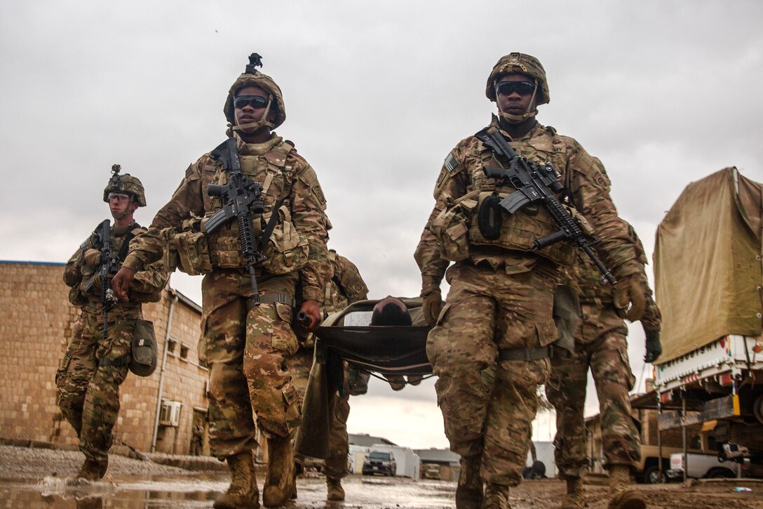 Army paratroopers transport a simulated casualty to a helicopter landing zone during medical evacuation training at Camp Swift in Makhmour, Iraq, Jan. 22, 2017. Army photo by Spc. Ian Ryan