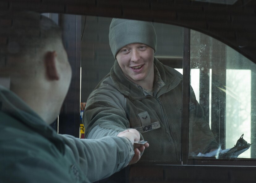 Airman 1st Class Jesse McVay, a 5th Security Forces Squadron installation entry controller, hands an I.D. card back to an Airman at Minot Air Force Base, N.D., Jan. 19, 2017. Security forces Airmen work long hours under normal and severe conditions to keep the base safe and secure. (U.S. Air Force photo/Airman 1st Class Alyssa M. Akers)