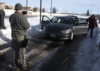 Senior Airman Brian Legrow and Airman 1st Class Michael Wyant, 5th Security Forces Squadron installation entry controllers, conduct a vehicle inspection at Minot Air Force Base, N.D., Jan. 19, 2017. All civilians requesting base access must first sign in at the Visitor’s Center then proceed to the inspection point. (U.S. Air Force photo/Airman 1st Class Alyssa M. Akers)